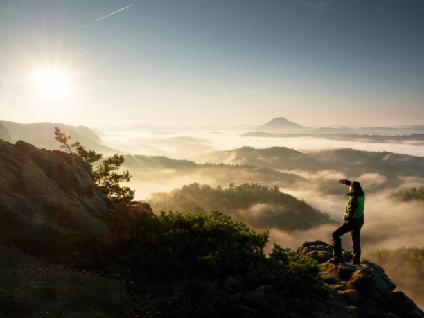 istock Man Silhouette Stay On Sharp Rock Peak. Satisfy Hiker Enjoy View. Tall Man On Cliff Watching Down 1253610139
