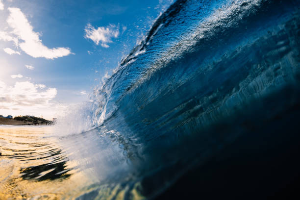 istock Barrel crashing wave in ocean with warm tones and beach 1253611136
