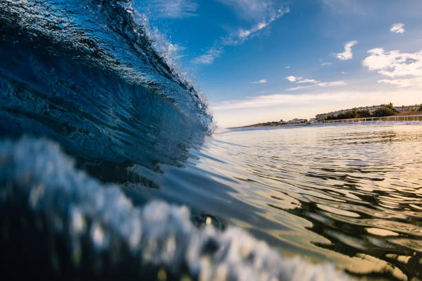 istock Barrel crashing wave in ocean with warm tones and beach 1253611166