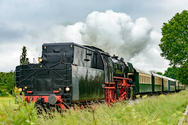 istock Vintage steam train pulling railway cars in a rural landscape 1253618635