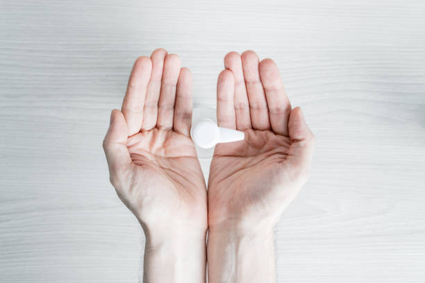 istock Hands under disinfectant dispenser waiting for hydroalcoholic gel, zenithal view 1253618684