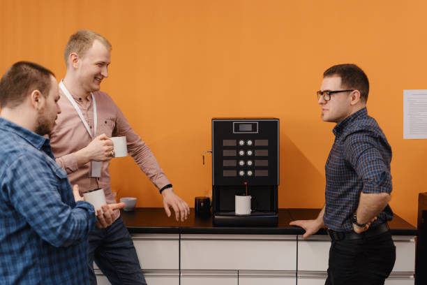 Group of coworkers having a coffee break Happy diverse colleagues have fun at lunch break in office, smiling multiracial employees laugh and drinking coffee. coffee maker stock pictures, royalty-free photos & images