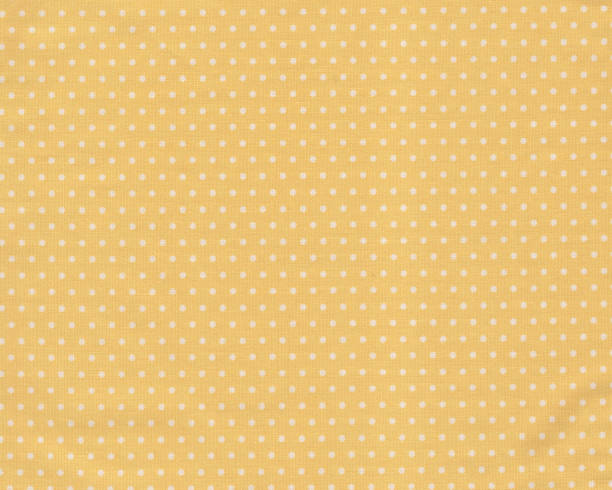 istock White polka dot over yellow fabric texture background. 1253620486