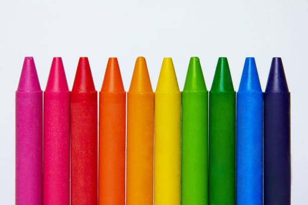 colored crayons and blank page on the wooden table