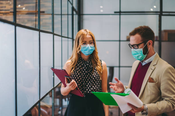 istock Businesspeople wearing protective face masks at work during COVID-19 1253622738