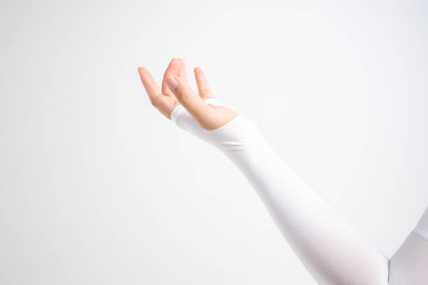 Hand with elastic wrist and arm support for relieve injury Hand with elastic wrist and arm support sleeve for relieve injury and sun block on white background sleeve photos stock pictures, royalty-free photos & images