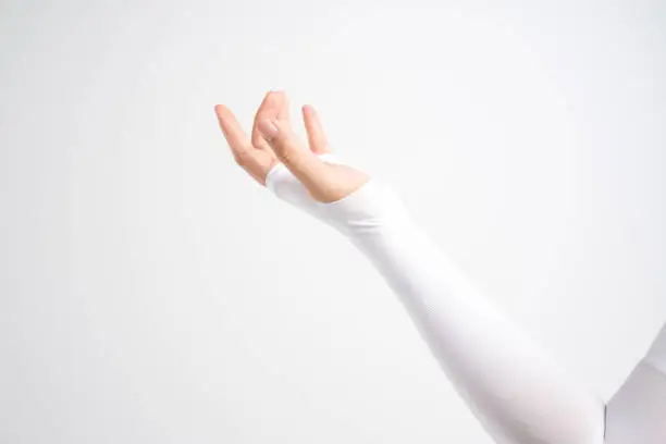 Hand with elastic wrist and arm support sleeve for relieve injury and sun block on white background