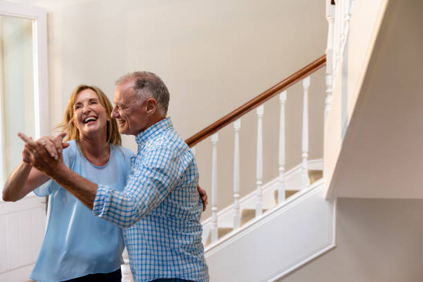 Caucasian couple having fun dancing and smiling in the hallway