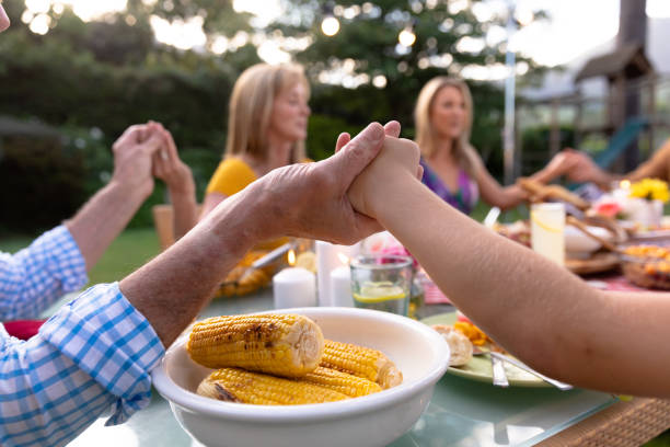 Caucasian family saying grace together before eating