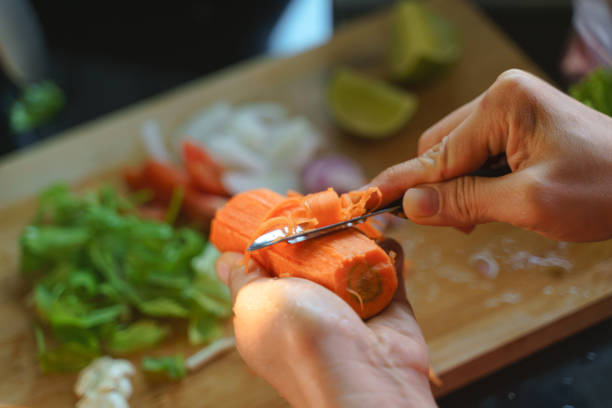 istock Hand slicing peeled carrot for cooking 1253627887