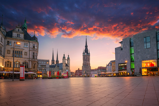 Cityscape image of historical downtown of Halle (Saale) with the Red Tower and the Market Place during dramatic sunset.