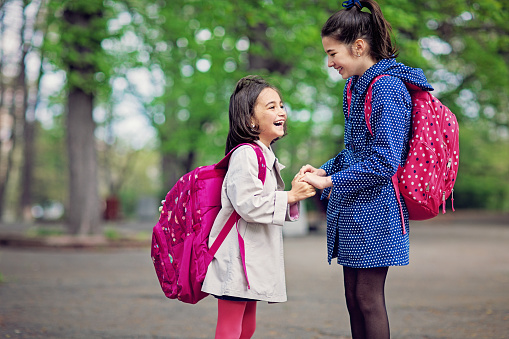 Schoolgirls are having fun in a park