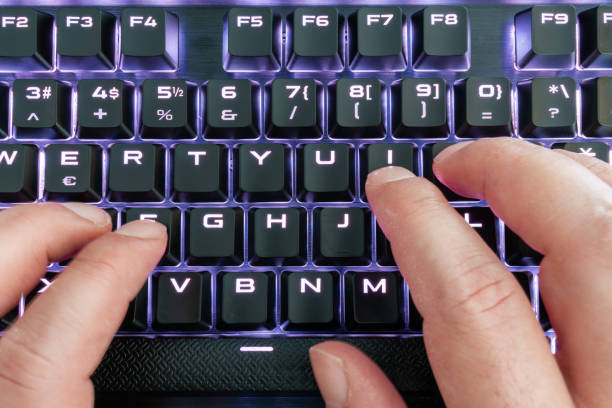 istock Closeup view of a keyboard with bright led lights for easy and comfortable using pc or notebook. High Tech concept. 1253629613