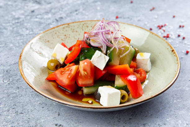 istock greek salad with cheese in a plate on a gray background 1253631906