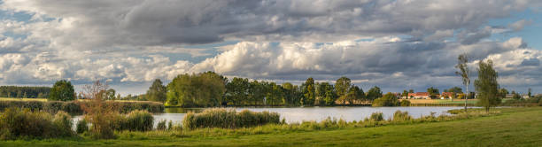 istock picturesque country landscape with pond 1253632162