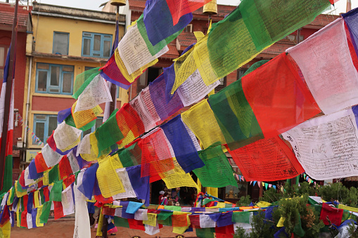 Stock photo showing prayer flags of primary colours hanging in the street around Boudhanath Stupa, Kathmandu, Nepal.