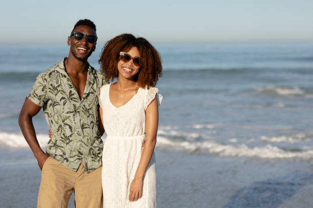 istock A mixed race couple posing and smiling on beach on a sunny day 1253634159