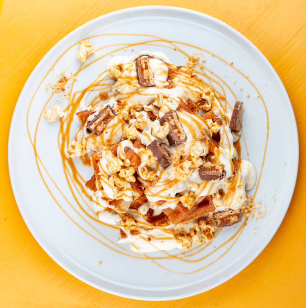 istock Belgian waffles with caramel topping, chocolate bars and popcorn. 1253634337