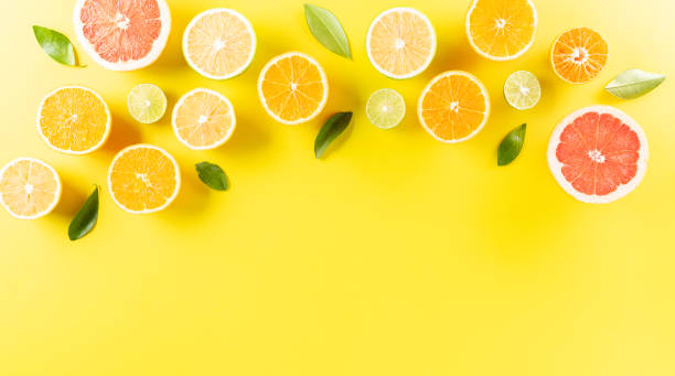 istock Summer composition made from oranges, lemon or lime on pastel yellow background. Fruit minimal concept. Flat lay, top view 1253639634