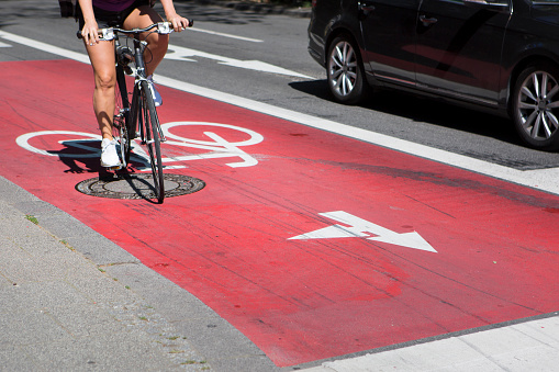 Bicycle lane, urban scene. Unreconizable female biker