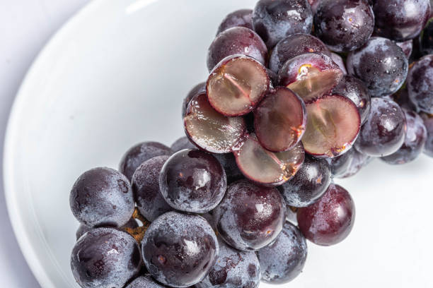 istock Kyoho Plump Kyoho grapes (giant mountain grapes) isolated on white in a dripping dish, sweet and delicious. 1253648506