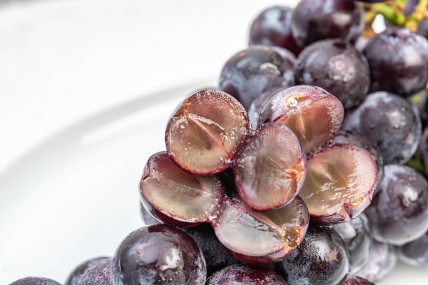 istock Kyoho Plump Kyoho grapes (giant mountain grapes) isolated on white in a dripping dish, sweet and delicious. 1253648507