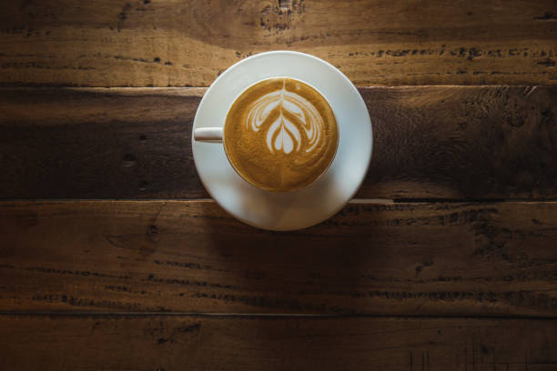 istock A cup of coffee with heart pattern in a white cup on wooden background 1253649256
