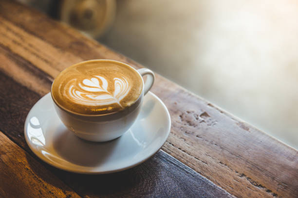 istock A cup of coffee with heart pattern in a white cup on wooden background 1253649263