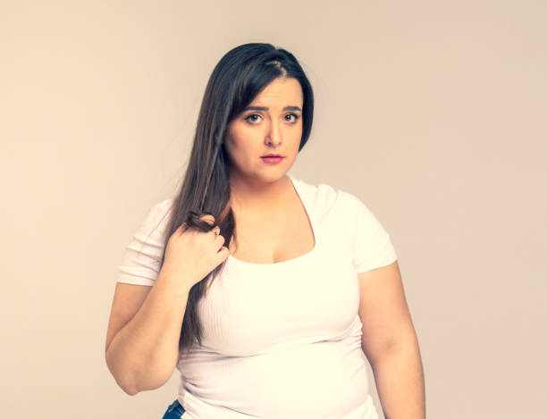 istock Plus Size Model with long hair twists hair on a finger 1253652132