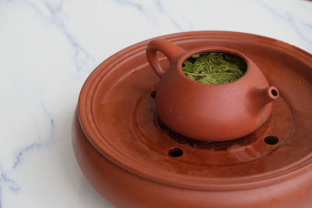 istock close up a pot of tea on white marble table. 1253652820