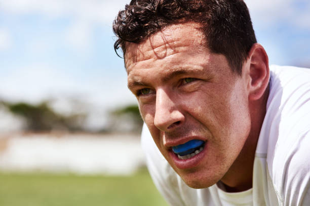 Collision sport requires a bit of extra protection Shot of a young man wearing a gum guard while playing a game of rugby mouthguard stock pictures, royalty-free photos & images