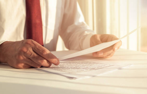 istock Businessman reading documents concept for analyzing a finance agreement or legal contract 1253654791