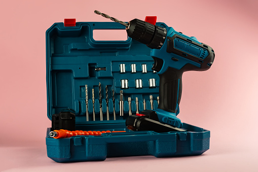 case with a screwdriver and nozzles on a pink background.