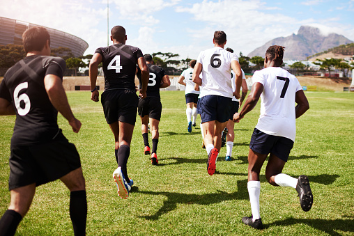 Shot of a group of young rugby players running onto the field during a game