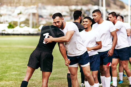 Shot of a group of young men shaking hands during a game of rugby