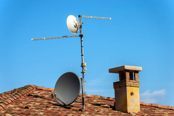 телевидение воздушные и спутниковые блюдо на крыше дома - satellite dish television aerial television house стоковые фото и изображения