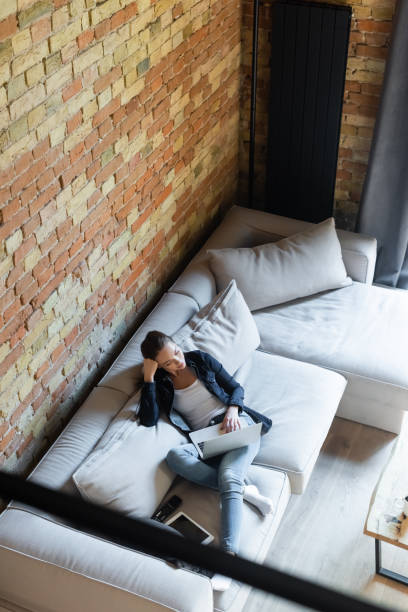istock overhead view of beautiful freelancer using laptop near digital tablet with blank screen on sofa 1253663597