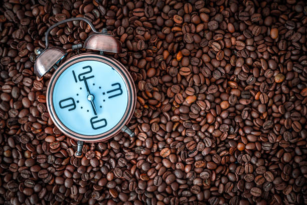 istock morning time coffee time. alarm clock on coffee beans. 1253666883