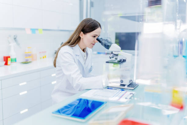 istock Female scientist during research. Using microscope in futuristic lab 1253668370