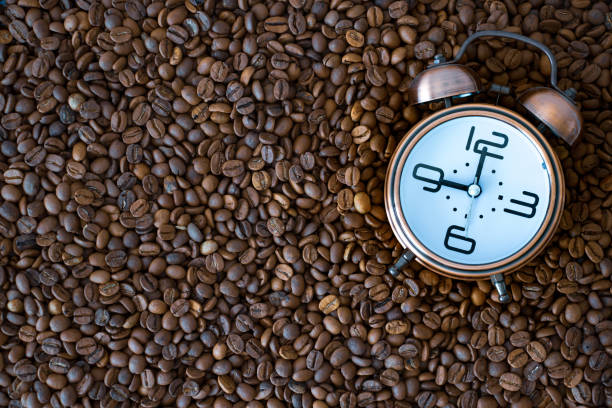 istock morning time coffee time. alarm clock on coffee beans. 1253668932