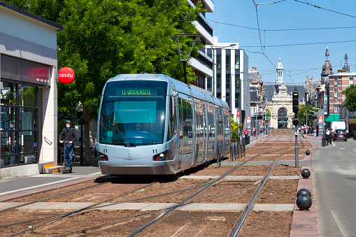 Valenciennes, France - June 23 2020: The Valenciennes tramway with the train station behind.