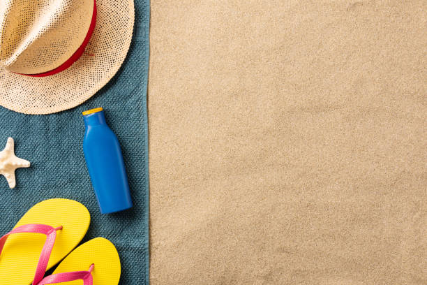 istock Summer beach accessories and sun cream on the sand 1253671671