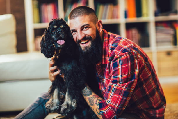 istock Handsome man with cute dog at home 1253671747