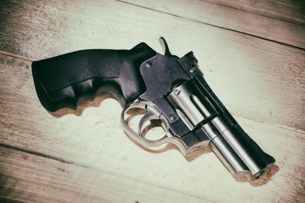 istock chrome revolver lies on a wooden table 1253671752