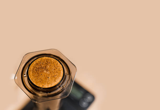 Coffee aeropress creams close-up with empty place for advert right side. Alternative coffee brewing method. Aeropress device on the table. Advert for social networks of restaurants, cafe.
