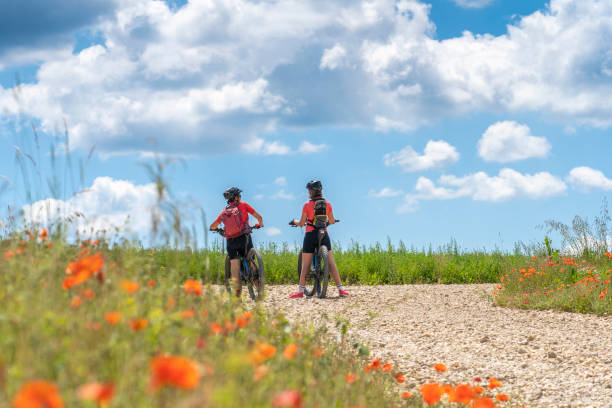 istock women with mountain bikes between poppies and blue cloud sky 1253673713