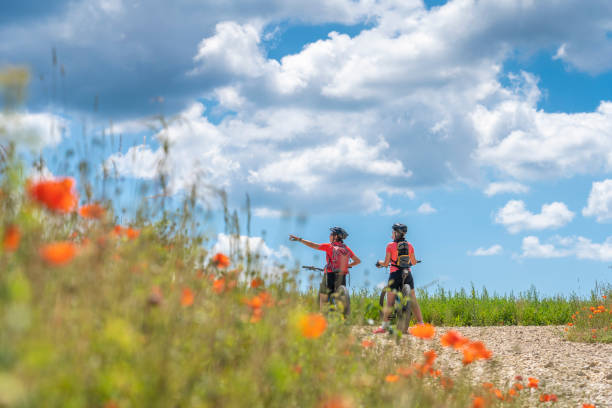 istock women with mountain bikes between poppies and blue cloud sky 1253673733