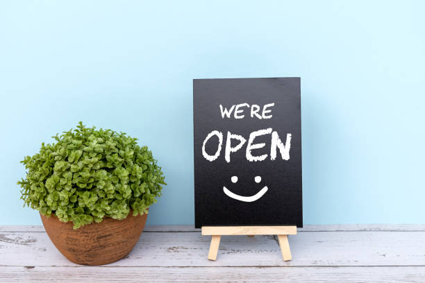 We're open sign on black board We're open sign on black board with potted plant open photos stock pictures, royalty-free photos & images