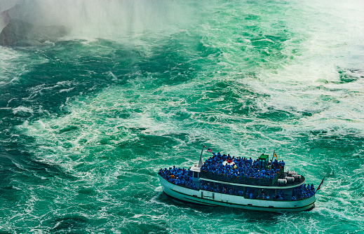 Canada side of Niagara falls with a tourist boat .Image made in summer season.
