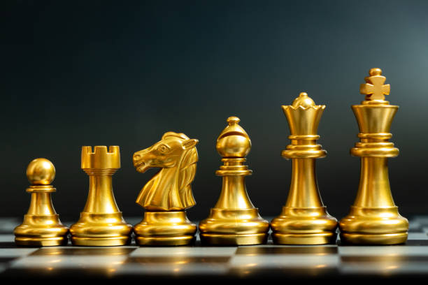 istock Gold chess piece stand in a row (king, queen, bishop, knight, rook, pawn) on black background 1253677588